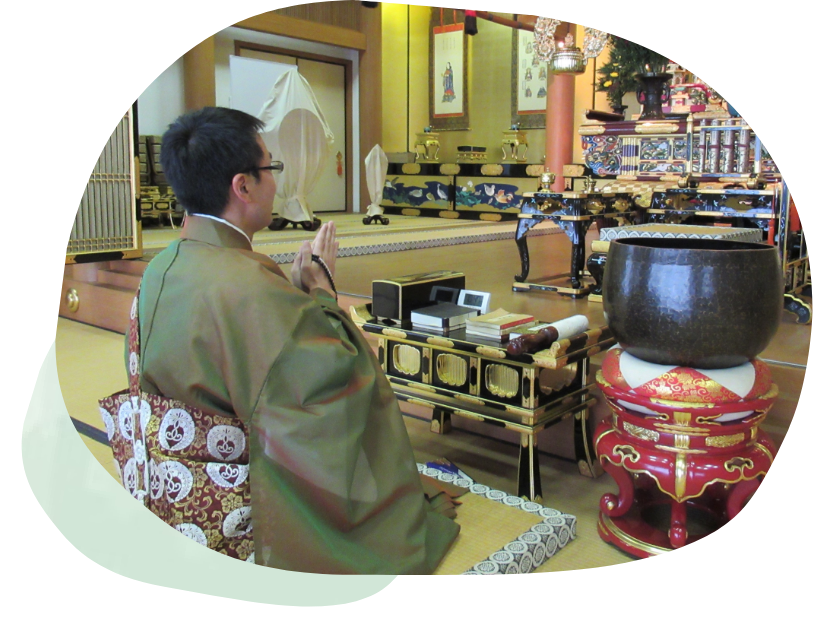 埼玉県越谷市にあるお寺の法光寺で、僧侶が手を合わせて合掌している様子です。